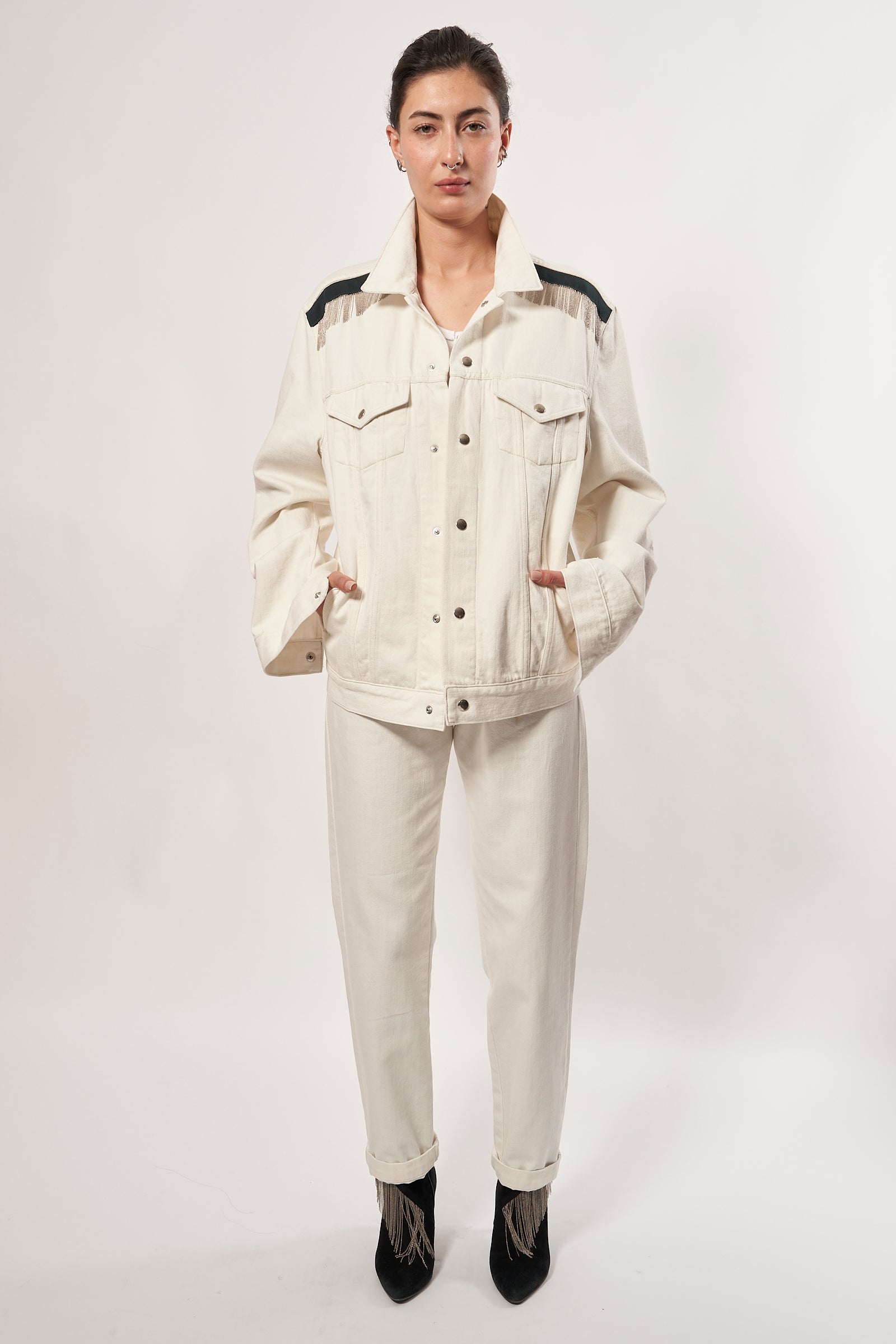 SARAH DE SAINT HUBERT ROMY CHAINS écru cotton denim jacket is the perfect blend of timeless design and modern style. Its signature hand-embroidered chains at the shoulders with dark green gros-grain tape and silver press buttons add a luxurious touch, giving it a boyish yet pure look. This jacket is sure to be your go-to for a timeless rock'n roll look. Limited edition Kara is 168 cm tall and wears a size M 100% cotton, Made in Portugal