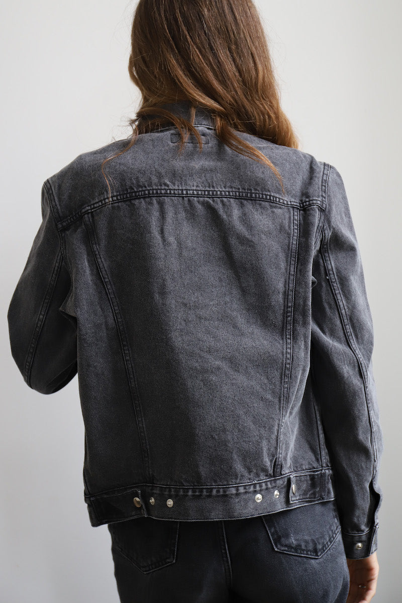 The SARAH DE SAINT HUBERT ROMY CHAINS off-black cotton denim jacket is the perfect blend of timeless design and modern style. Its signature hand-embroidered chains at the shoulders with dark green gros-grain tape and silver press buttons add a luxurious touch, giving it a boyish yet pure look. This jacket is sure to be your go-to for a timeless rock'n roll look. Boyfriend fit. 100% cotton, Made in Portugal