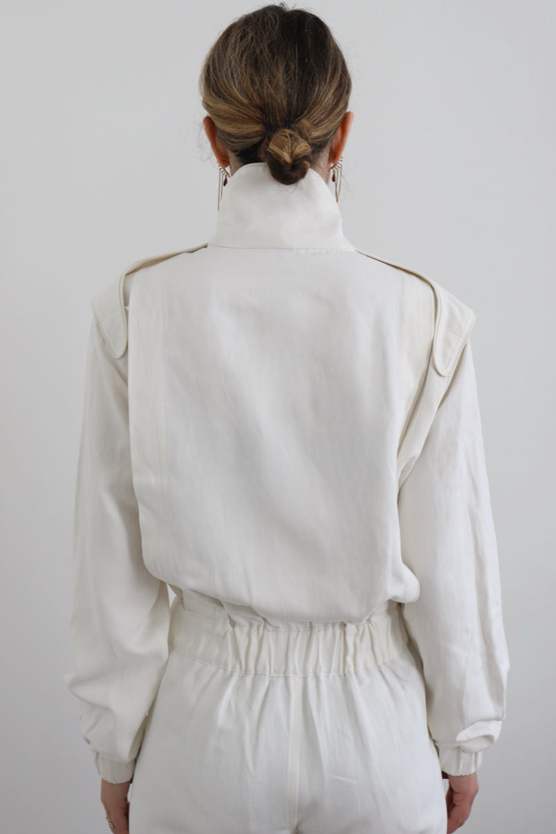 SARAH DE SAINT HUBERT Heritage racing jumpsuit with SDSH signature details. Beautiful silk-hemp fabric sourced from a Luxury House deadstock. Beige gros-grain finishings. Iconic rows of metal snaps at the collar and waist. Boyish and feminine look. Straight and relaxed fit. Made in Portugal