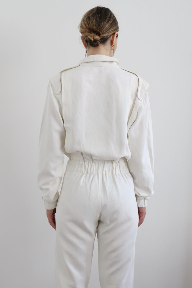 SARAH DE SAINT HUBERT Heritage racing jumpsuit with SDSH signature details. Beautiful silk-hemp fabric sourced from a Luxury House deadstock. Beige gros-grain finishings. Iconic rows of metal snaps at the collar and waist. Boyish and feminine look. Straight and relaxed fit. Made in Portugal