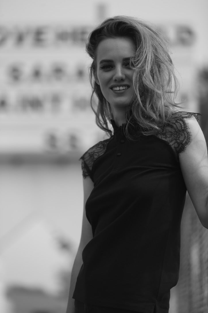 SARAH DE SAINT HUBERT black piqué polo shirt made of cotton piqué jersey with calais lace insert at the shoulders. A timeless feminine polo shirt with a straight/tiny fit.