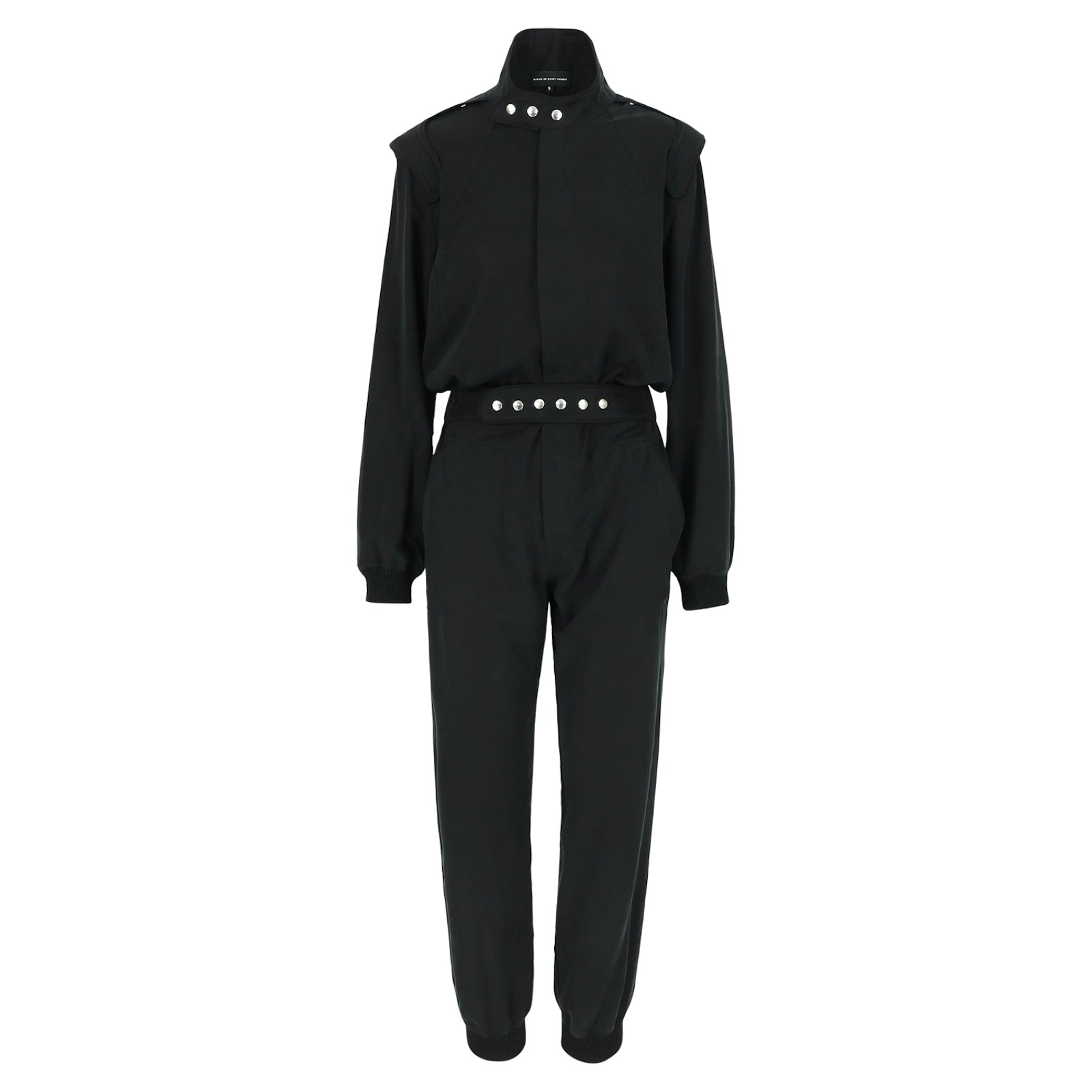 SARAH DE SAINT HUBERT Heritage racing jumpsuit with SDSH signature details. Black gros-grain trimming around the neck and waist belt. Iconic rows of metal snaps at the collar and waist. Wear it baggy for a boyish look. Wear it tightened at the waist for a more feminine look. Straight and relaxed fit. Black tencel (natural fibers). 100% tn. Made in Portugal