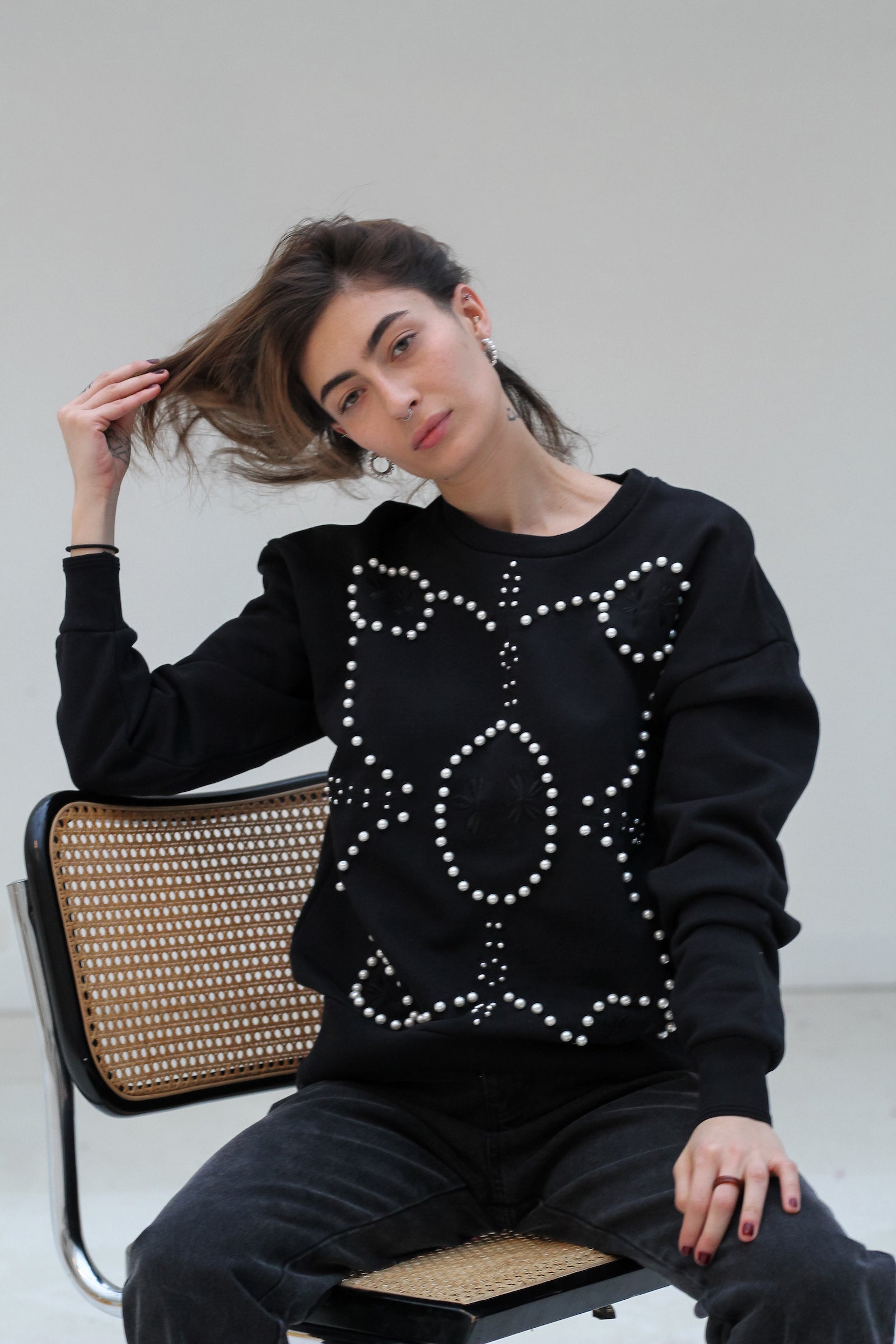 Signature Sweatshirt featuring our iconic 'broderie anglaise' at the front. Hand-embroidered in BELGIUM with large Pearls (Perles de Mallorque). Hand-embroidered in BELGIUM with small pearls (Perles de culture, type 'grains de riz') relaxed fit, dropped shoulders. 100% black cotton Kara is 168 cm tall and wears a size XS Made in Portugal, embroidered in Belgium other sizes available on demand