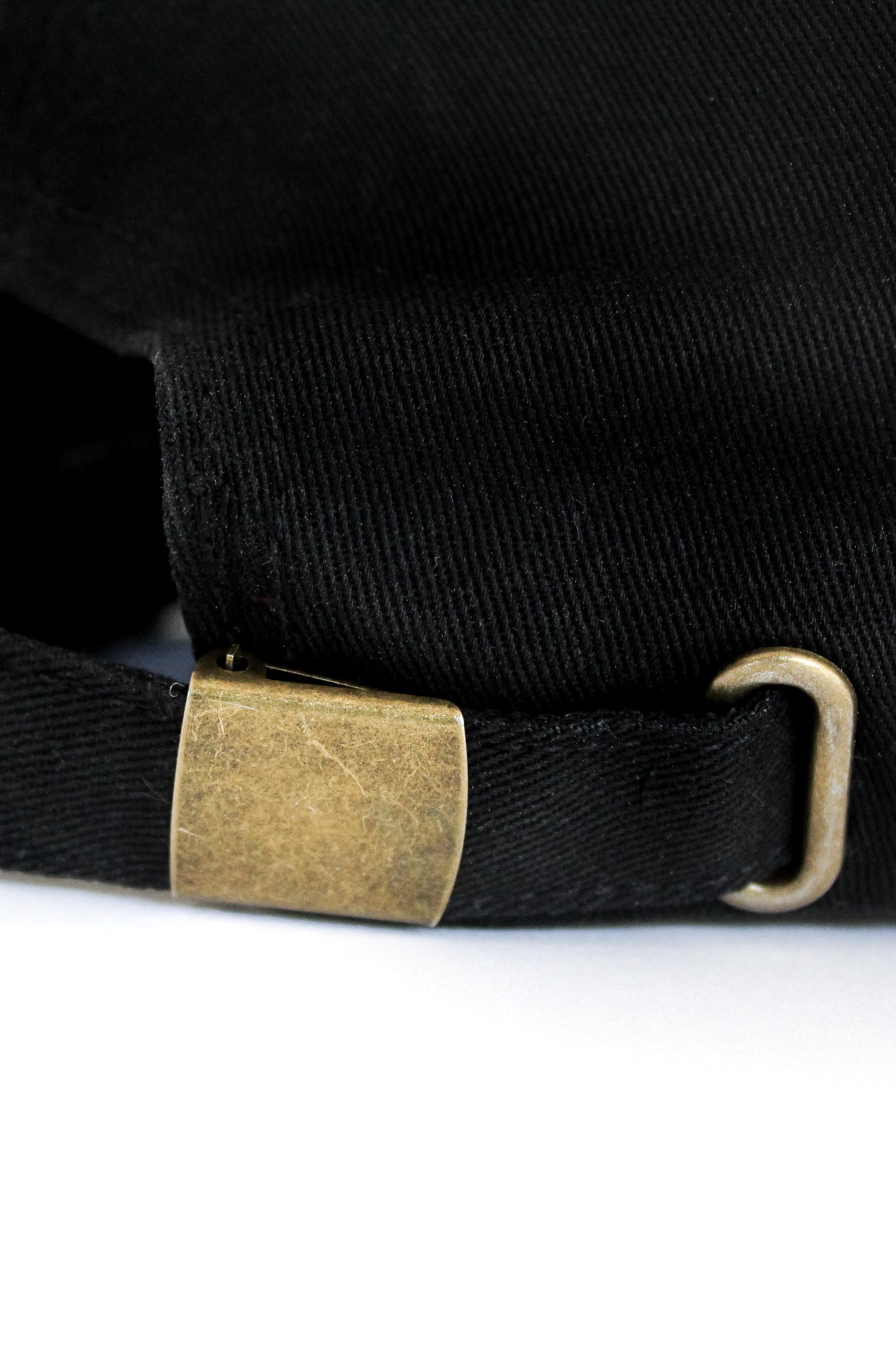 Black cotton baseball cap, 6 panels White 3-D embroidered SDSH monogram curved peak with 6 brim stitches reinforced 2 front panels adjustable fabric strap closure with metal buckle & loop inside printed tape 'FOLLOW YOUR WILD LOVE' 100% cotton twill