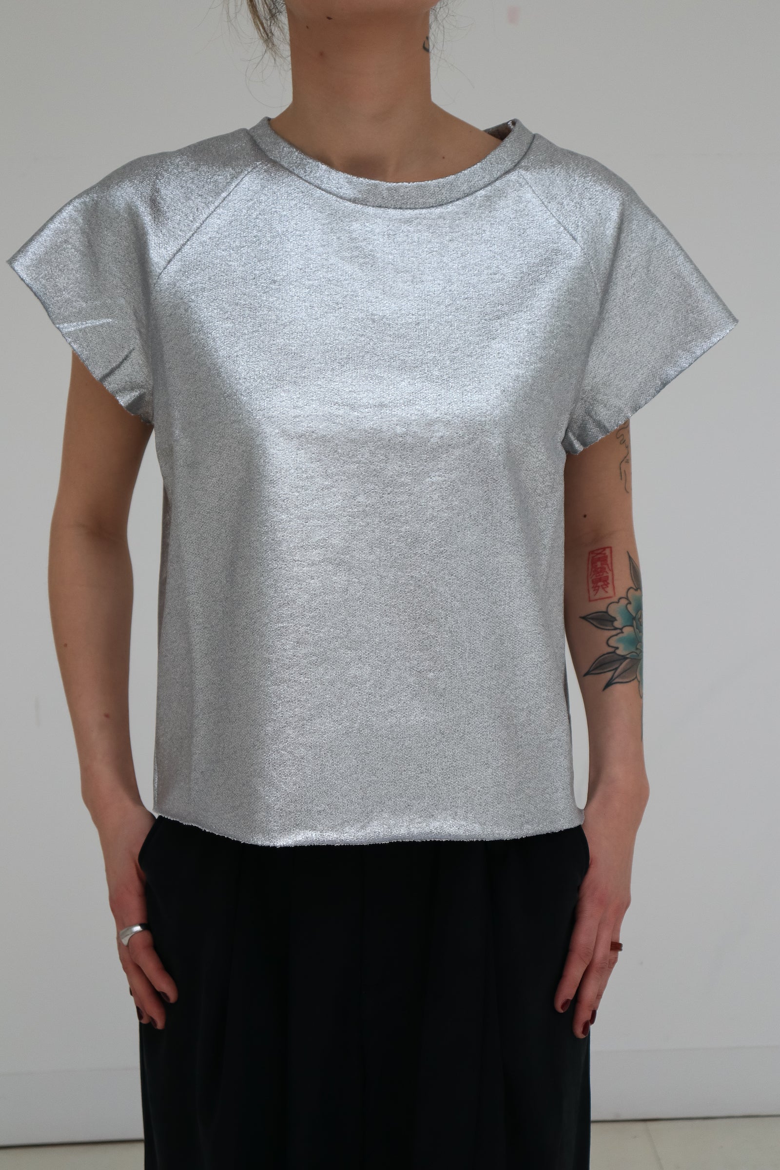 Rock and shinny! For a special occasion, to party all night long, or just stand out a little more, the Nadine sweater/T-shirt was made for you! Go wild! It has a straight fit, slightly cropped, and features raw cut raglan sleeves and a raw cut hem. Made in a 100% silver coated cotton, in Portugal Louise is 170 cm tall and wears a size M