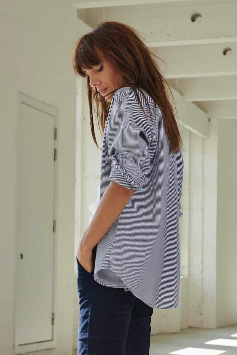 Chemise de smoking SARAH DE SAINT HUBERT à rayures marines en viscose avec applications de volants. Une chemise féminine intemporelle avec une coupe droite/relaxée.