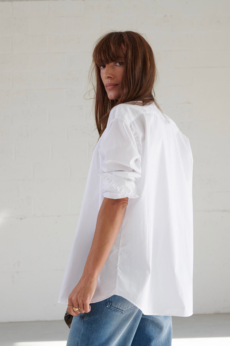 SARAH DE SAINT HUBERT chemise smoking blanche en viscose avec applications de volants. Une chemise féminine intemporelle avec une coupe droite/relaxée.