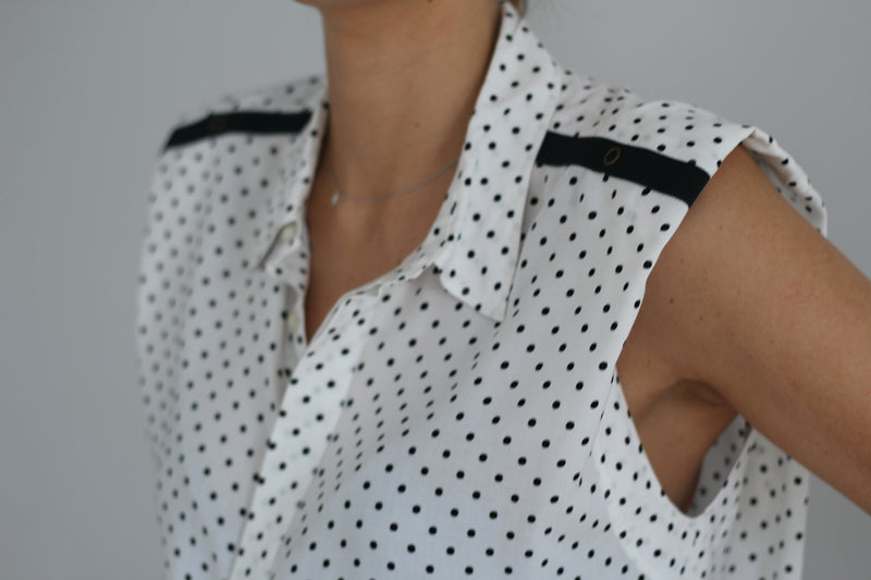 SARAH DE SAINT HUBERT fluid shirt made of viscose. A timeless feminine shirt with a relaxed fit. Fluid black printed dots shirt with 'straight shoulder pads' look. Shoulders can be worn either loose or folded inside to get the look. Black gros-grain tape with press buttons at the shoulders. Blind placket at the front side. Loose & straight fit, true to size 100% viscose Made in Portugal.