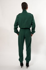 SARAH DE SAINT HUBERT Heritage racing jumpsuit with SDSH signature details. Dark green gros-grain trimming around the neck and waist belt. Iconic rows of metal snaps at the collar and waist. Wear it baggy for a boyish look. Wear it tightened at the waist for a more feminine look. Straight and relaxed fit. Black tencel (natural fibers). 100% tn. Made in Portugal