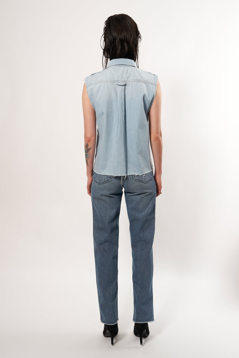 SARAH DE SAINT HUBERT light blue cotton denim boyfriend shirt. A timeless feminine shirt with a straight/relaxed fit. Signature black snaps buttonning at front & sleeves cuffs. Two front pockets & pleat at the back. Straight fit. Kara is 168 cm tall and wears a size S. 100% cotton. Made in Turkey, upcycled in Brussels