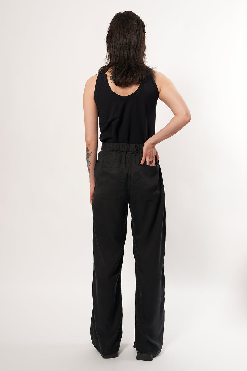 Confortable and fluid trousers in Tencel fabric, colour black. A casual chic outfit. Elasticated waistband, wide and straight fit at the legs. 2 front and back pockets. Designed in Belgium, made in Portugal.