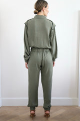 SARAH DE SAINT HUBERT Heritage racing jumpsuit with SDSH signature details. Dark green gros-grain trimming around the neck and waist belt. Iconic rows of metal snaps at the collar and waist. Wear it baggy for a boyish look. Wear it tightened at the waist for a more feminine look. Straight and relaxed fit. Khaki tencel (natural fibers). 100% tn. Designed in Belgium, Made in Portugal