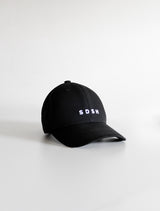 Black cotton baseball cap, 6 panels White 3-D embroidered SDSH monogram curved peak with 6 brim stitches reinforced 2 front panels adjustable fabric strap closure with metal buckle & loop inside printed tape 'FOLLOW YOUR WILD LOVE' 100% cotton twill