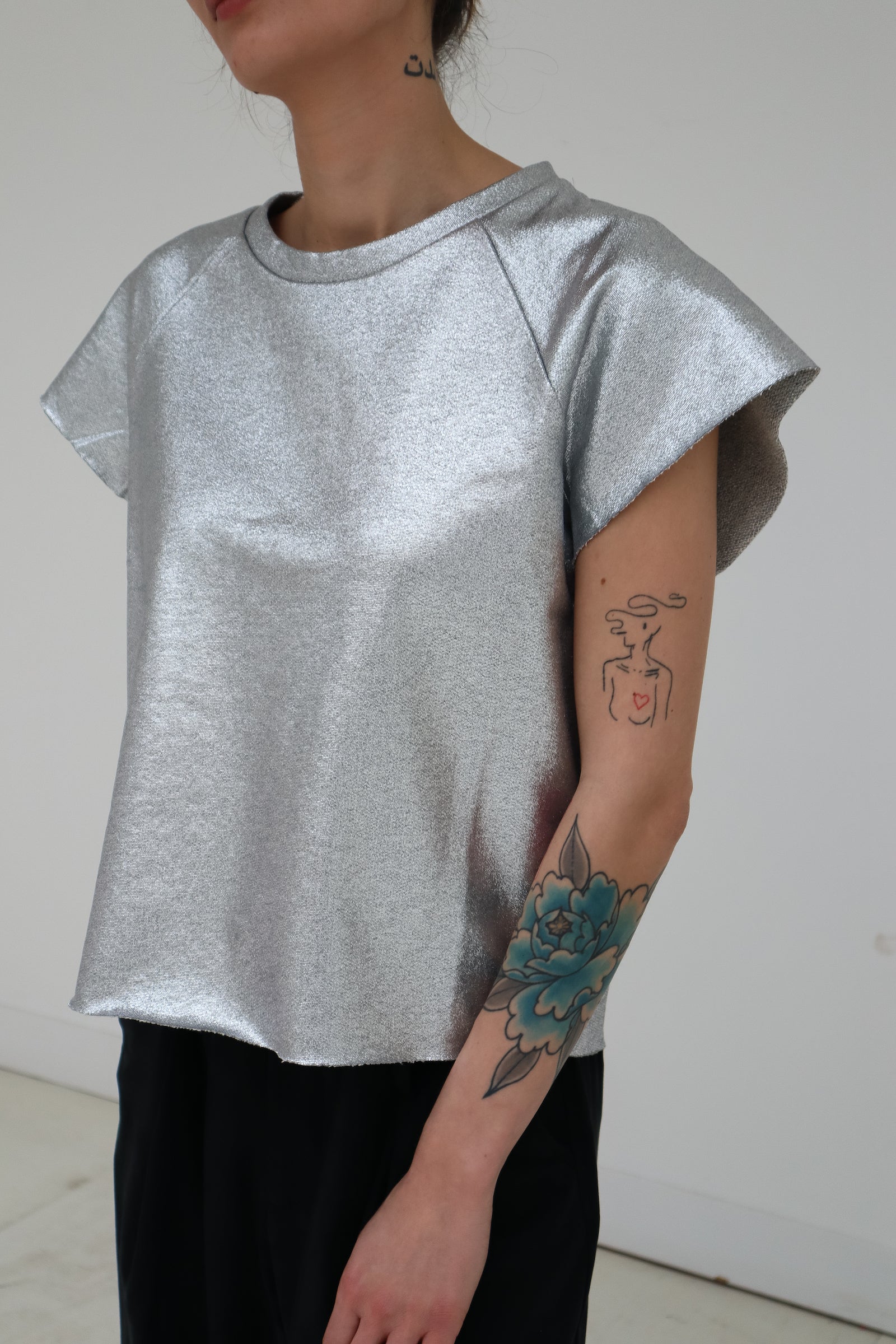 Rock and shinny! For a special occasion, to party all night long, or just stand out a little more, the Nadine sweater/T-shirt was made for you! Go wild! It has a straight fit, slightly cropped, and features raw cut raglan sleeves and a raw cut hem. Made in a 100% silver coated cotton, in Portugal Louise is 170 cm tall and wears a size M